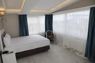 a bedroom with a bed and a large window at Novus Hotel İstanbul in Istanbul