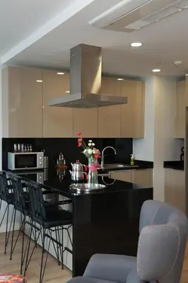 a kitchen with a black counter top and chairs at Lovely One Plus One BDROOM-836 in Istanbul