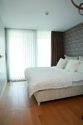 a bedroom with a large bed with white sheets and windows at Lovely One Plus One BDROOM-836 in Istanbul