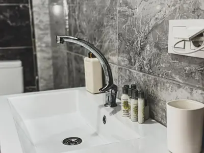 a bathroom sink with a faucet and bottles on it at Doğanın Kalbindeki Eviniz-9 Kişi in Gemlik