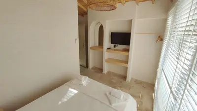 a white bathroom with a tub and a tv at The Roof Ada in Adalar