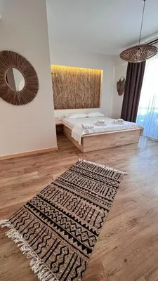 a bedroom with a bed and a rug on a wooden floor at The Roof Ada in Adalar