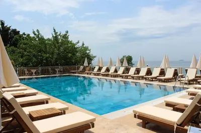 a swimming pool with lounge chairs and umbrellas at The Roof Ada in Adalar
