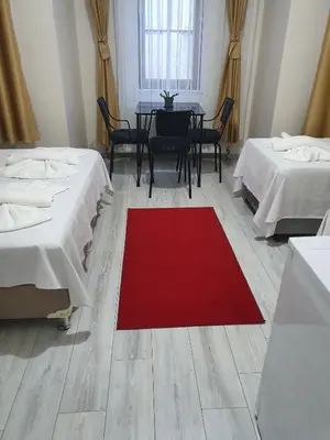a room with two beds and a red rug on the floor at Halil Bey Konağı in Istanbul