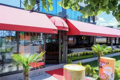 a store front with red awnings on a street at Brand Business Hotel in Corlu
