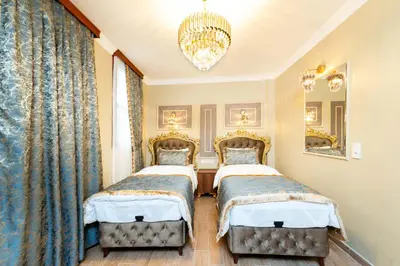 a bedroom with two beds and a chandelier at Brown Mansion Oldcity in Istanbul