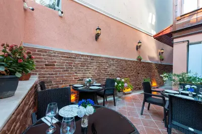 a patio with tables and chairs and a brick wall at Brown Mansion Oldcity in Istanbul