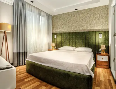 a bedroom with a large bed with a green headboard at La Mia Suites in Istanbul