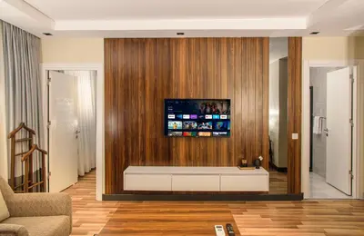 a living room with a tv on a wooden wall at La Mia Suites in Istanbul