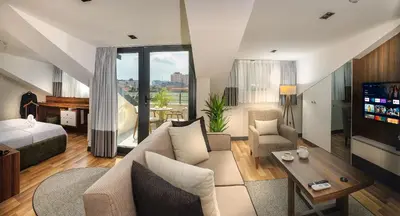 a living room with a couch and a bed and a television at La Mia Suites in Istanbul