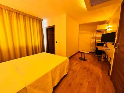 a hotel room with a bed and a desk at Nice Royal Cıty in Istanbul