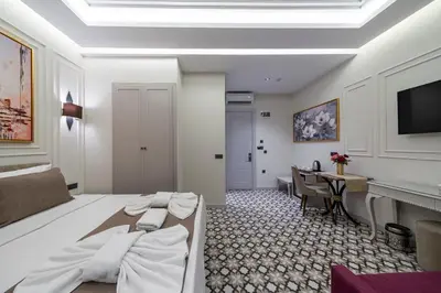 a bedroom with a bed and a desk and a television at Pera Luna Premium Hotel in Istanbul