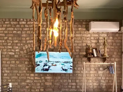 a picture hanging from a brick wall with a chandelier at Balat Historical House in Istanbul