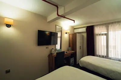 a hotel room with two beds and a desk and a television at Galata Greenland Hotel in Istanbul