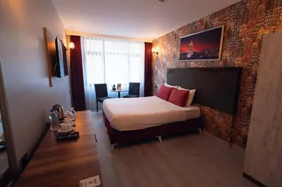 a hotel room with a bed and a brick wall at Galata Greenland Hotel in Istanbul