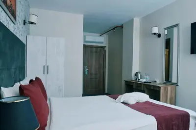 a bedroom with a white bed with red pillows at Galata Greenland Hotel in Istanbul