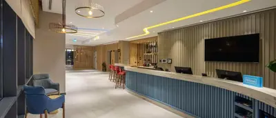 a lobby with a bar with chairs and a tv at Hampton By Hilton Cerkezkoy in Tekirdag