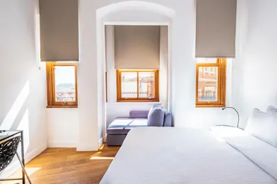a bedroom with two beds and two windows at Homie Suites - Historical Apartment Nearby Galata Tower in Istanbul