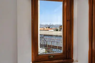 a wooden window with a view of a building at Homie Suites - Historical Apartment Nearby Galata Tower in Istanbul
