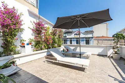 a patio with an umbrella and chairs on a balcony at Bdino Boutique Hotel in Istanbul