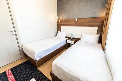 two beds in a small room with white sheets at Blue Vista Houses & Spa in Esenyurt
