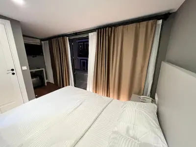 a bedroom with a white bed and a window at TAKSİM GOKOTTA SUiTE in Istanbul