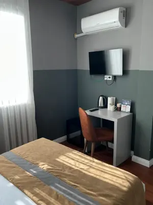 a room with a bed and a desk with a television at TAKSİM GOKOTTA SUiTE in Istanbul