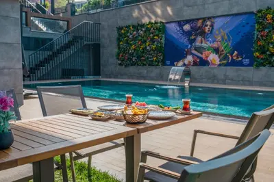 a table with food on it next to a swimming pool at La Miel Şile in Sile