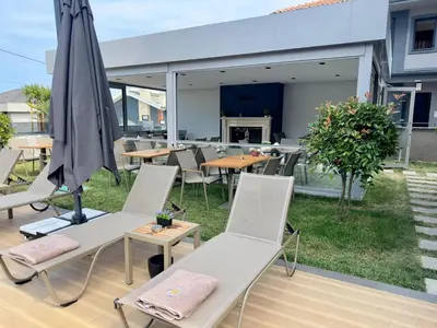 an outdoor patio with chairs and an umbrella at La Miel Şile in Sile