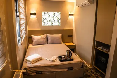 a small bed in a small room with a window at CK PALACE Hotel in Istanbul