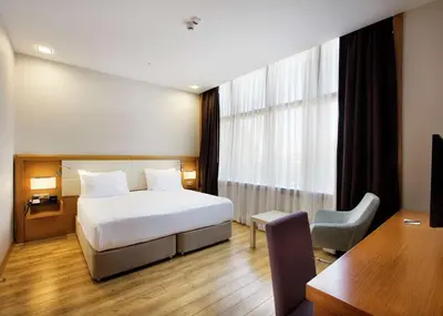 a hotel room with a bed and a desk at Hilton Garden Inn Kocaeli Sekerpinar in Şekerpınarı