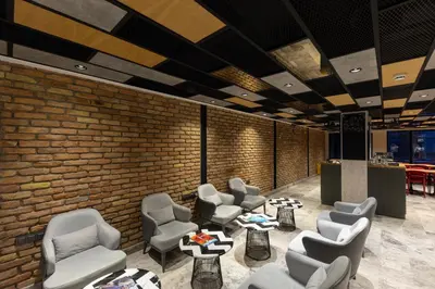 a waiting room with chairs and tables and a brick wall at AHG Atlas Hotel Taksim in Istanbul