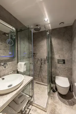 a bathroom with a shower and a sink and a toilet at AHG Atlas Hotel Taksim in Istanbul