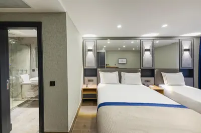 a hotel room with two beds and a bathroom at AHG Atlas Hotel Taksim in Istanbul