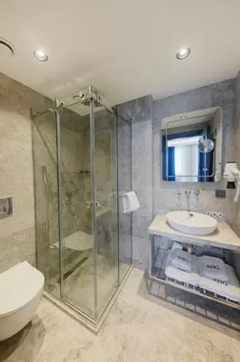 a bathroom with a shower and a toilet and a sink at AHG Atlas Hotel Taksim in Istanbul