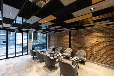 a lobby with chairs and tables and a brick wall at AHG Atlas Hotel Taksim in Istanbul