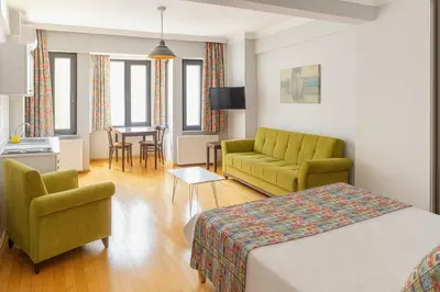 a hotel room with a bed and chairs and a table at Istanberry - Vanilla Apartments in Istanbul