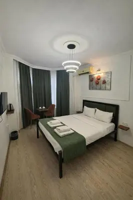 a bedroom with a large bed with a green blanket at 24 BOUTİQUE HOTEL in Istanbul
