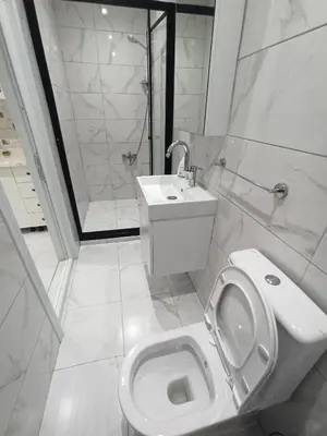 a white bathroom with a toilet and a sink at CEM Apart in Istanbul