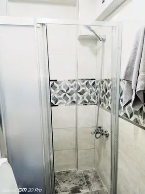 a shower with a glass door in a bathroom at Orbital Travel House 1 in Istanbul