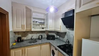 a kitchen with white cabinets and a sink at Cozy Spacious near Green Mosque in Yıldırım