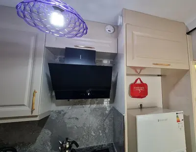 a kitchen with a tv and a refrigerator at Cozy Spacious near Green Mosque in Yıldırım