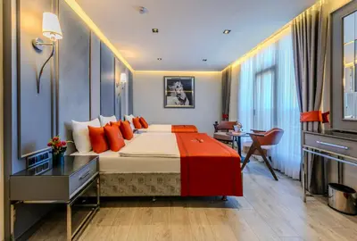 a bedroom with a large bed with orange pillows at Atar Airport Hotel - Restaurant & Spa Wellness in Arnavutköy