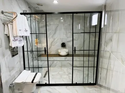 a bathroom with a glass shower with a toilet at Atar Airport Hotel - Restaurant & Spa Wellness in Arnavutköy