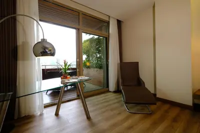 a living room with a glass table and a chair at Gorrion Hotel Istanbul in Istanbul