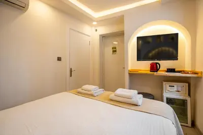 a bedroom with a white bed with two towels at Emir Hotel in Istanbul