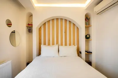 a bedroom with a large white bed with a wooden headboard at Emir Hotel in Istanbul