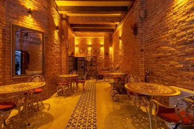 a room with tables and chairs and a brick wall at The First Ottoman Apartments in Istanbul