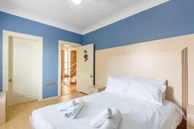 a bedroom with blue walls and a bed with towels on it at Villa Moon in Gebze