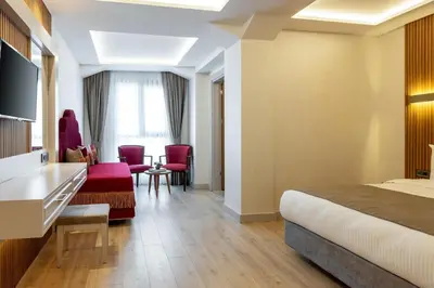 a hotel room with a bed and a table and chairs at Carina Gold Hotel And Restaurant in Istanbul